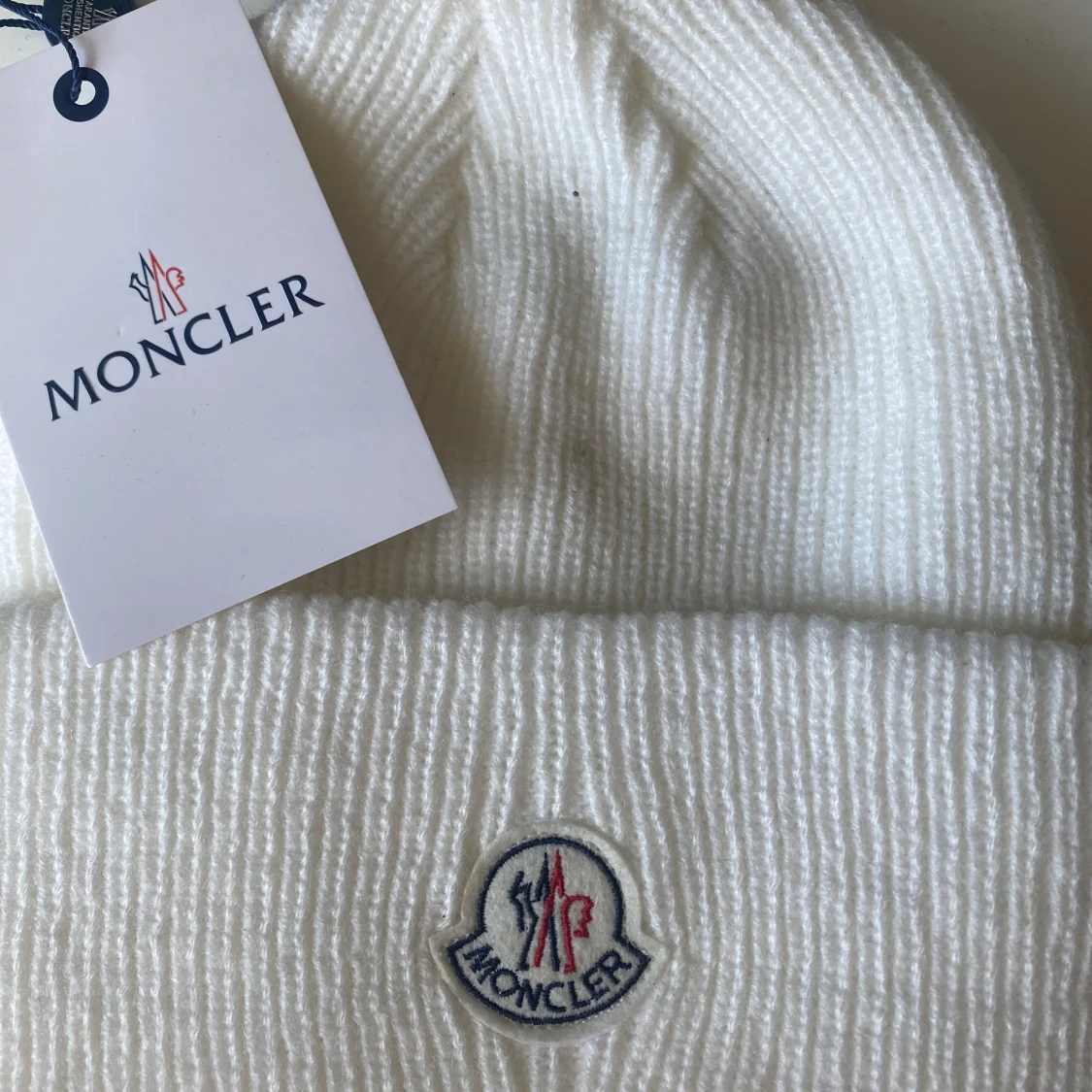 Vit ribbstickad mössa från Moncler med Tagg