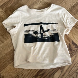Baby tee T-shirt  - En skit snygg baby tee T-shirt med svart tryck på. Säljer för att den inte passar mig längre. 💕