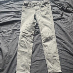 Grå skinny jeans från Jack & Jones - Snygga ljusgrå skinny jeans från Jack & Jones i klassisk femficksmodell. Jeansen har normal midja och är tillverkade i mjuk bomullsdenim med lite stretch för extra komfort. Perfekta för dig som gillar en smal passform och stilren look.