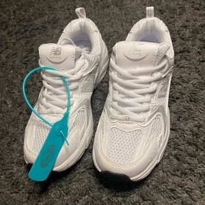 Vita New Balance 530 sneakers - Fräscha vita New Balance 530 sneakers med mesh och syntetpaneler för en sportig vibe. Klassisk siluett med rund tå, snörning och detaljer i silver. Perfekta för dig som gillar stilrena och bekväma skor till vardags. Funkar på storlek 36 med.
