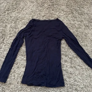 Mörkblå långärmad tröja Intimissimi - Säljer en tunn och mjuk mörkblå långärmad tröja från Intimissimi. Tröjan är i en slim passform och tillverkad i en lyxig blandning av modal och kashmir, vilket gör den superbekväm och perfekt för lager-på-lager. Enkel och stilren design utan detaljer.