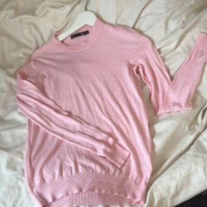 Ljusrosa stickad tröja från 157, XS - Supersöt ljusrosa stickad tröja från 157 i storlek XS. Tröjan har rund halsringning, långa ärmar och ribbade muddar vid ärmslut och nederkant. Aldrig andvänd fick i present och den var lite för stor 