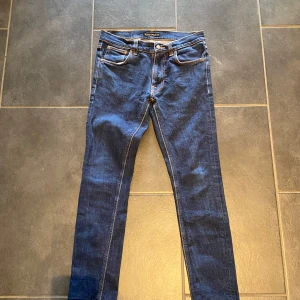 Nudie Jeans - Säljer ett par klassiska Nudie jeans i modellen slim fit. Jeansen är i riktigt bra skick (9/10), bekväma och passar perfekt till både vardag och fest. Storlek: 30/32. Ett måste i varje garderob! Hör gärna av dig vid funderingar eller intresse! Tar gärna fler foton om det önskas!