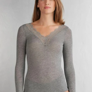 Grå intimissimi topp med spetsdetaljer - Jätte fin grå intimissimi tröja. Den är helt ny och aldrig använd, säljer eftersom jag råkade ta av lappen så jag kan inte lämna tillbaka den💕
