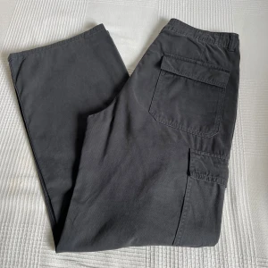 Gråa cargobyxor från Zara - Ett par cargobyxor i en urtvättad grå färg från Zara. Byxorna har en rak modell och har fickor både bak och på sidorna. 