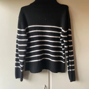 Randig svartvit Gina Tricot - Säljer en svart  från Gina Tricot med vita horisontella ränder. Tröjan är stickad Perfekt för dig som gillar klassisk stil med en twist. Passar dig som vill ha en mysig och snygg tröja 