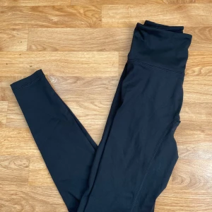 Lumi tights från Relode - Snygga svarta lumi tights från Relode med hög midja och tight passform. Tillverkade i ett stretchigt och mjukt syntetmaterial som passar perfekt till träning eller chill. Stilrena utan synliga detaljer eller mönster. Endast prövade💕Nypris 699kr.