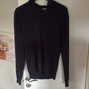 Svart merinoull hoodie från Reiss - Svart hoodie från Reiss i 100% mjuk merinoull. Enkel och stilren design med lång ärm och huva, perfekt för dig som gillar en clean look. Passar dig som vill ha något bekvämt men ändå snyggt till vardags. Storlek M för den har krympt 