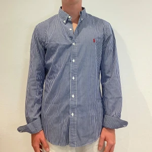 Randig Ralph Lauren Skjorta - Vit/ blå Randig Ralph lauren skjorta || Storlek M (Slim Fit) || Skjortan är i bra skick || Mitt pris 599kr || Modellen på bilden är 170cm och väger 62kg || Tveka inte på att höra av dig vid frågor eller funderingar 