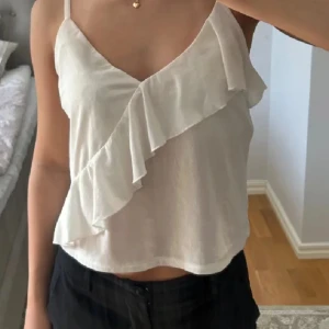 Vit linnetopp med volang - Säljer en söt vit linnetopp med smala axelband och volangdetalj framtill. Toppen har en lätt och luftig känsla, perfekt för varma dagar. Säljer då den är för stor för mig, köpt här på plick och gamla ägares bild. 💞