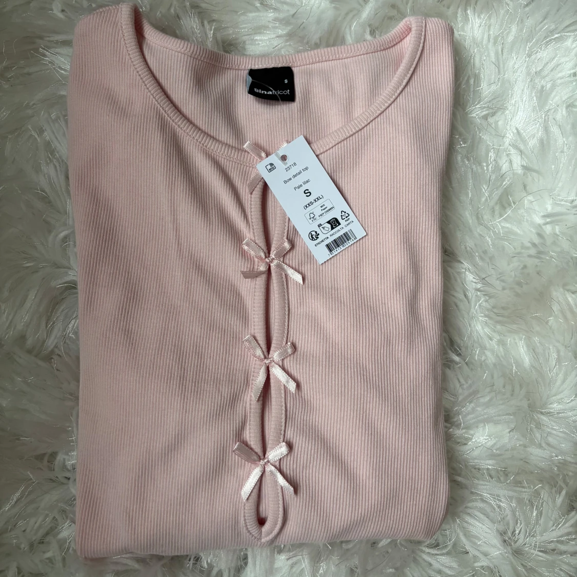 Ljusrosa ribbad topp med rosetter Gina Tricot