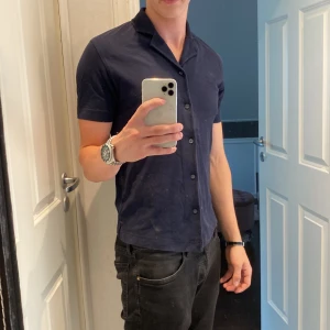 Marinblå kortärmad skjorta Dressmann - Snygg marinblå pike från Dressmann med knappar i mycket bra skick! Hör av er vid minsta frågor! Pris kan diskuteras!🍾