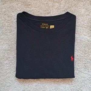 Svart Ralph Lauren T-shirt - Stl S/170 - Fin Ralph Lauren T-shirt I färgen svart 😎| Skick: 8,5/10 förutom ett litet hål som inte syns vid användning | Stl: Xl 18-20 som är en barnstorlek och passar Stl S, passar bäst runt 170cm lång | Fraktar spårbart med Instabox eller Postnord | Mvh, Galgen 🤗