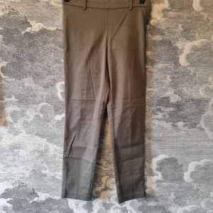 Khakigröna kostymbyxor - Kostymbyxor från H&M i en klassisk stil. är i mycket bra skick. Jag hittar ingenting att anmärka på.