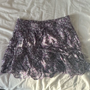 Blommig kjol från Zara - Säljer en söt blommig kjol från Zara i storlek S. Kjolen har ett elastiskt midjeband och ett volangigt fall. De är även inne shorts i som är så bra!Perfekt för en somrig look! 🌸