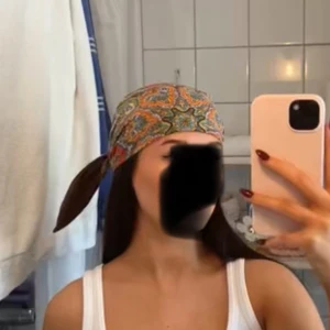 Mönstrad sjal i paisley - Snygg sjal med paisleymönster i färgerna röd, orange, blå och grön. Perfekt att använda som huvudbonad eller accessoar. Materialet ser ut att vara mjukt och bekvämt.