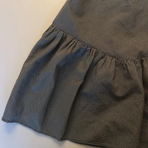 Rutig kjol med volang - Snygg kortkjol i svartvitt rutigt mönster med volangdetalj. Perfekt för en trendig look. Kjolen har en normal passform och är lätt att matcha med olika toppar.