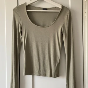 Grön långärmad topp från Gina Tricot - Säljer en stilren grön långärmad topp från Gina Tricot. Soft touch – second skin comfort. Långärmad topp i mjuk viskos med figurnära passform. Toppen har djup halsringning. Den har långa ärmar med slits vid ärmsluten och är tillverkad i ett mjukt material som ger en skön passform. Perfekt för en avslappnad look. Använt max två gånger💕