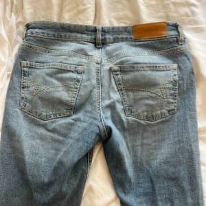 Blå jeans från Junkyard - Snygga blå jeans från Junkyard med bootcut-stil. Lowwaisted o skitsnygga men används tyvärr inte längre. Bakre fickan har en defekt (se sista bild) men det går säkert att sy ihop