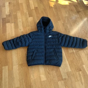 Vårjacka junior från Nike 137-147 cm - Säljer en svart junior vårjacka från Nike med huva och dragkedja. Jackan är tunn och passar perfekt för våren. Storlek 137-147 cm