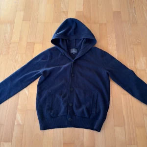 Cardigan med luva  - En fet cardigan med luva från less worries. Ny pris ligger på 1800. Inga skador men den kan vara lite nopprig på sina ställen. Vid frågor eller funderingar är de bara att höra av sig. 