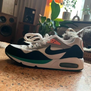 Nike Air sneakers - Snygga Nike Air sneakers i vitt och svart med orangea och gröna detaljer. Dom är i fint skick. Det är storlek 38, men skulle säga att dom är mer 37.