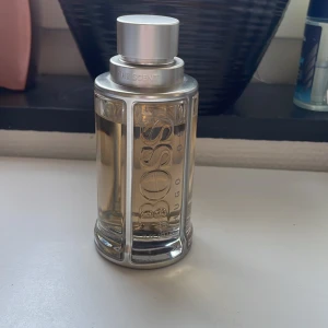 Parfym Hugo Boss The Scent 100ml - Säljer en elegant parfym från Hugo Boss, The Scent. Flaskan är genomskinlig med silverdetaljer och har en stilren design. Doften är maskulin och sofistikerad, perfekt för den som vill ha en klassisk och tidlös parfym. Söt-fräsch appelsin doft, jätte fin för våren. Ca 90ml kvar. 