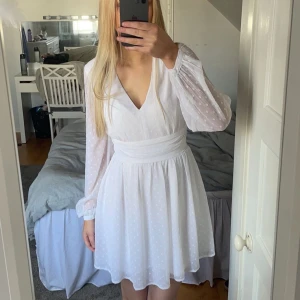 Vit klänning från Bubbleroom - Vit klänning från Bubbleroom med v-ringning, lång ärm och knytning bak. Nypris 600kr