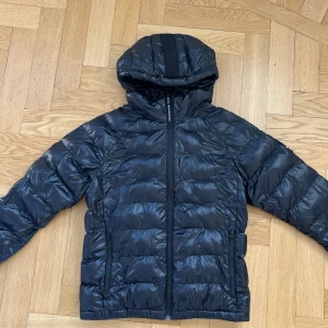 Svart dunjacka från Peak Performance - Superfin glansig dunjacka ifrån Peak Performance💕 Storlek S💕 I superfint skick, förutom hålet på bild 5! 4000kr nypris, priset kan diskuteras!