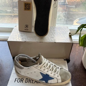 Golden Goose 40 - Riktigt feta Golden Goose i storlek 40. Box dustbag och passport medföljer. Skorna är i bra skick, och har en unik blå stjärna. Skriv gärna till mig om ni skulle ha någon fråga. Priset kan diskuteras vid väldigt snabb affär.