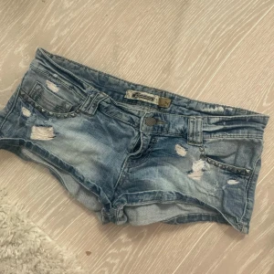 Blå jeansshorts med slitningar - Säljer dessa skit snygga jeanse shorts i xs/34💖🙏 perfekt för sommaren💕 förra ägarens bilder( Midjemåttet är 38 cm)