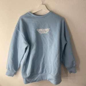 Ljusblå sweatshirt med tryck - Säljer en ljusblå sweatshirt med tryckt på bröstet. Ska flytta snart så vill gärna bli av med allt så fort som möjligt (pris kan diskuteras)💕