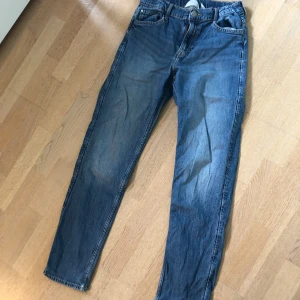 Blå jeans - Klassiska blå jeansbyxor med fem fickor och normal passform. Byxorna har raka ben och traditionell dragkedja samt knapp framtill. Perfekta för en avslappnad stil och passar till det mesta i garderoben.