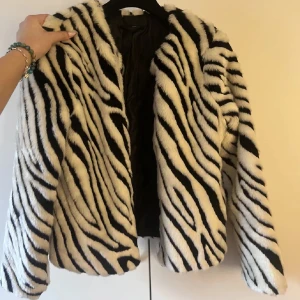 Zebramönstrad pälsjacka - Säljer en snygg zebramönstrad pälsjacka i svart och vitt. Jackan har lång ärm och är oversized. Så bra skick!