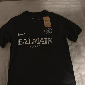 Svart PSG x Balmain fotbollströja  - Säljer en svart PSG x Balmain fotbollströja från Nike. Tröjan har korta ärmar. Storlek S passar S/m helt ny aldrig använd 