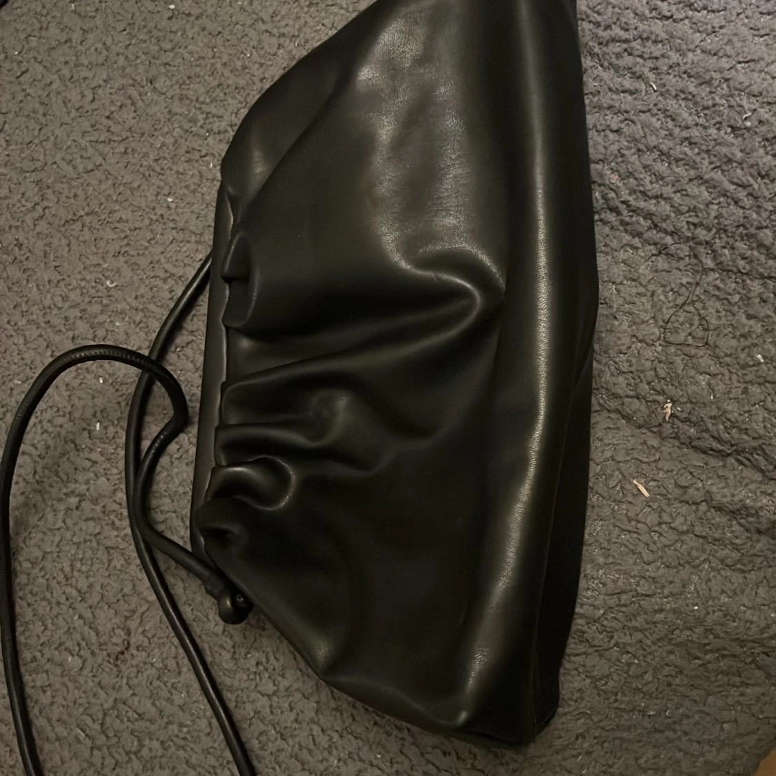 Svart axelväska i syntet