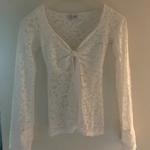 Vit spetsblus med knyt framtill - Säljer min Design By Si topp. Använd fåtal gånger men har lite defekter (syns på bilderna).     Ord. pris 453 