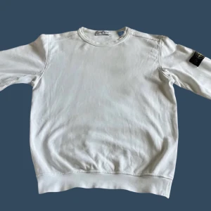 Vit Stone Island tröja, junior stl 156 (12) - Säljer stone island tröja i bra skick (Lite sliten därav priset) nypris 2000kr. Storleken är 156 (12y). Skriv för mer detaljerad information. 👍