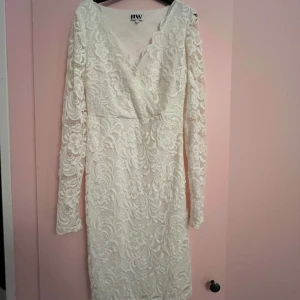 Vit spetsklänning med v-ringning från Make Way - Vit spetsklänning från Make Way i storlek XS. Klänningen har lång ärm, v-ringad omlott framtill och är täckt av vacker spets. Perfekt för speciella tillfällen när du vill känna dig extra fin. Använd 1 gång🫶🏼