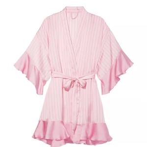 Victoria's Secret rosa ruffle robe - Supersöt rosa och vit randig kimono från Victoria's Secret med volangdetaljer på ärmar och nederkant. Knytband (syns inte på bild men medföljer!) i midjan och vida ärmar ger en lyxig känsla. Perfekt att slänga på sig hemma eller på spa. Oanvänd.