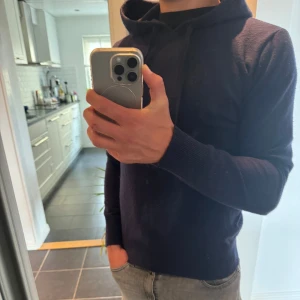 Mörkblå chasmire hoodie från William de Faye - Säljer en stilren mörkblå cashmire hoodie från William de Faye. Tröjan är använd fåtal gånger storlek M men passar S och Xs hör av er för eventulla frågor!!