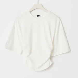 Vit croppad topp - Säljer en stilren vit croppad topp med korta ärmar. Sitter löst uppe och tight i midjan. Passar bra till jeans eller kjol.