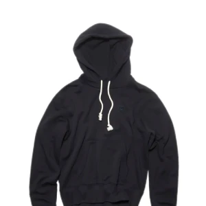 Svart hoodie från Acne - Svart hoodie med huva och vita dragsnören från acne . Klassisk känguruficka framtill  Perfekt för en avslappnad stil. Tjock och skön i materialet 