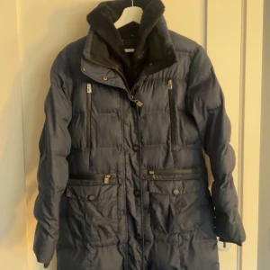 Lång ridjacka - Säljer en mörkblå jacka från JH collection orginalpris: 1195kr. Många fickor och jätte skön för jag kall dag eller för vintern. Otroligt skönt material!