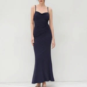 Mörkblå långklänning med spetsdetalj från Cider - Säljer en elegant mörkblå långklänning från Cider med smala axelband och draperad effekt framtill. Klänningen har en vacker spetsdetalj på insidan av bysten och en figurnära passform. Perfekt för speciella tillfällen! Bal, event och bröllop. Klänningen är ny och inte använd alls. Skriv för bättre bilder 💕