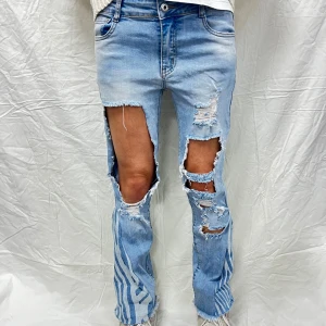 Blå zebra jeans med slitningar  - Blå, utsvängda zebra jeans med låg midja och slitningar på båda benen. Storlek: EUR 38. Mått: Innerbenslängd: 65 cm, Midjemått: 72 cm.