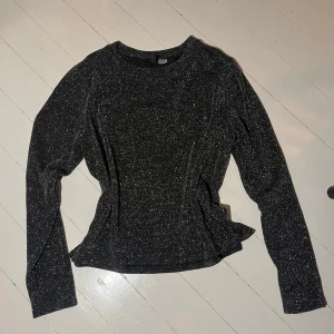 Svart glittrig långärmad topp - Säljer en svart långärmad topp med glittrigt material. Snygg och enkel modell med rund halsringning, perfekt för att sticka ut lite extra. Passar till många olika outfits och är superenkel att styla. Skriv för fler bilder💞