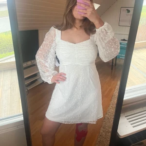 Studentklänning  - Säljer en söt studentklänning med långa puffärmar i spets och fyrkantig urringning. Klänningen har markerad midja och dragkedja i ryggen. Perfekt för somriga tillfällen. Helt ny och oanvänd från bubbleroom för 900kr