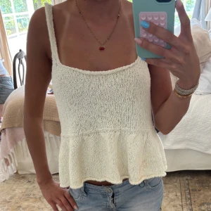 Vit stickad linnetopp med volang - Säljer en söt vit stickad linnetopp med fyrkantig ringning och volang nertill. Från Zara 