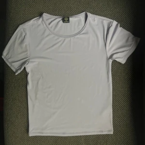 Ljusgrå t-shirt från Urban Outfitters - En stilren ljusgrå t-shirt från Urban Outfitters i storlek M, men passar bra till XS/S oxå.              T-shirten har rund halsringning och korta ärmar. Materialet känns mjukt och lätt, perfekt för en clean och enkel look. 